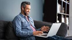 Hispanic businessman on video call on laptop, working at home