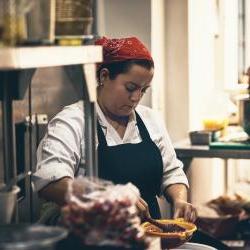一名西班牙裔女子在餐厅厨房里戴着头巾